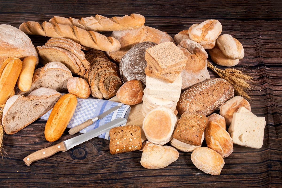 Fresh Assortment of several baked bread varieties on a wooden table. Fresh Assortment of several baked bread varieties on a wooden table.